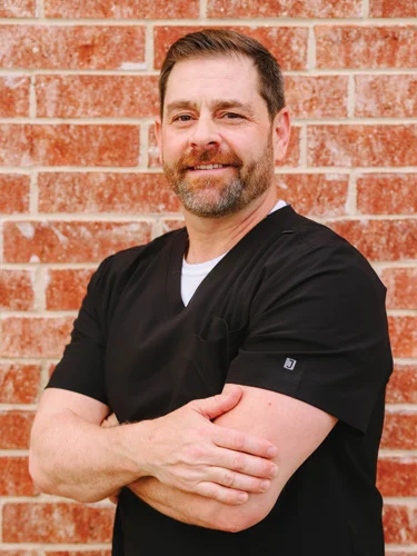 Chiropractor Allen TX Michael Wojnicki Thank You Dr. Michael Wojnicki smiling in front of a brick wall.